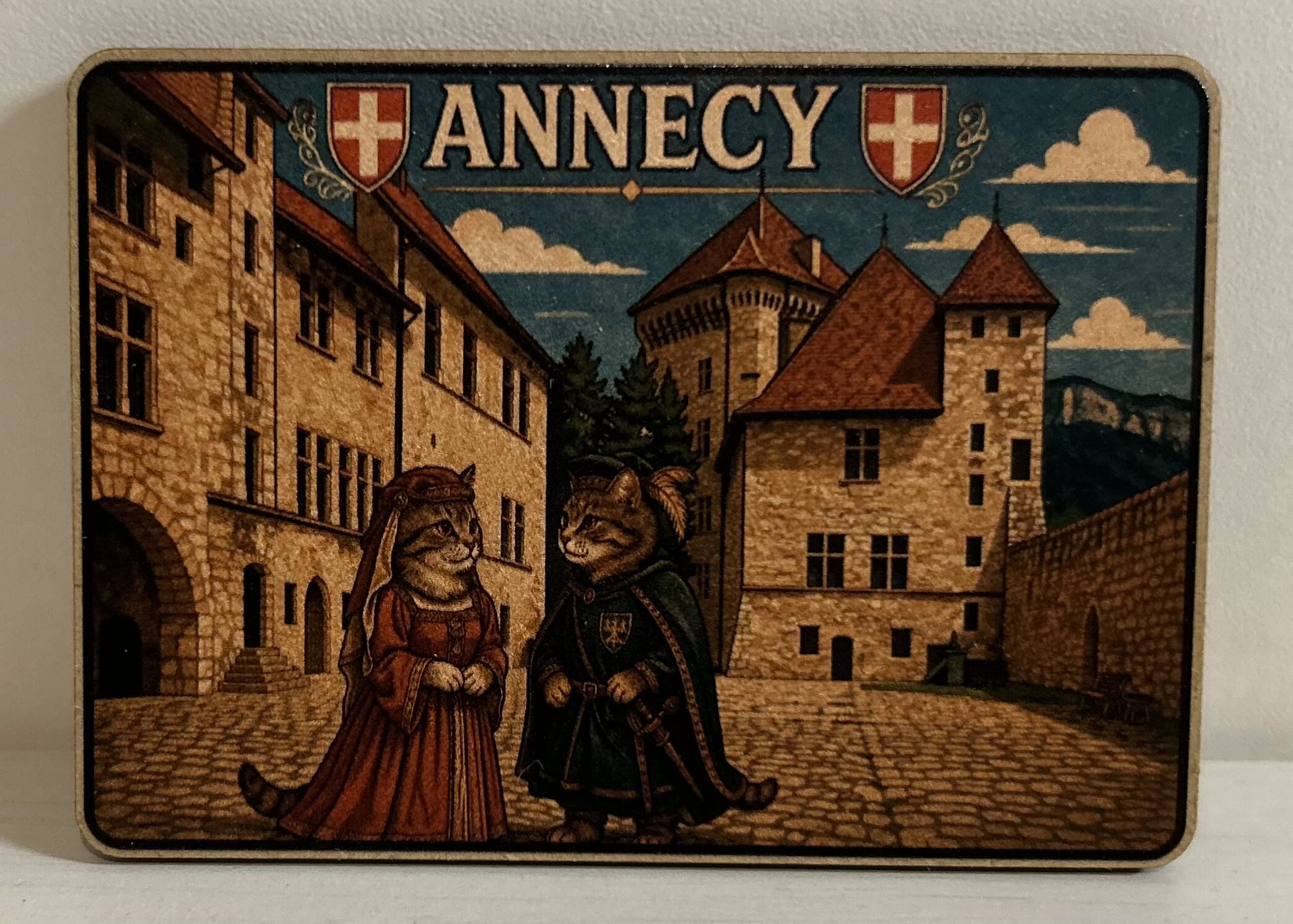 magnet en bois avec deux chats habillés en époque devant le chateau d'annecy