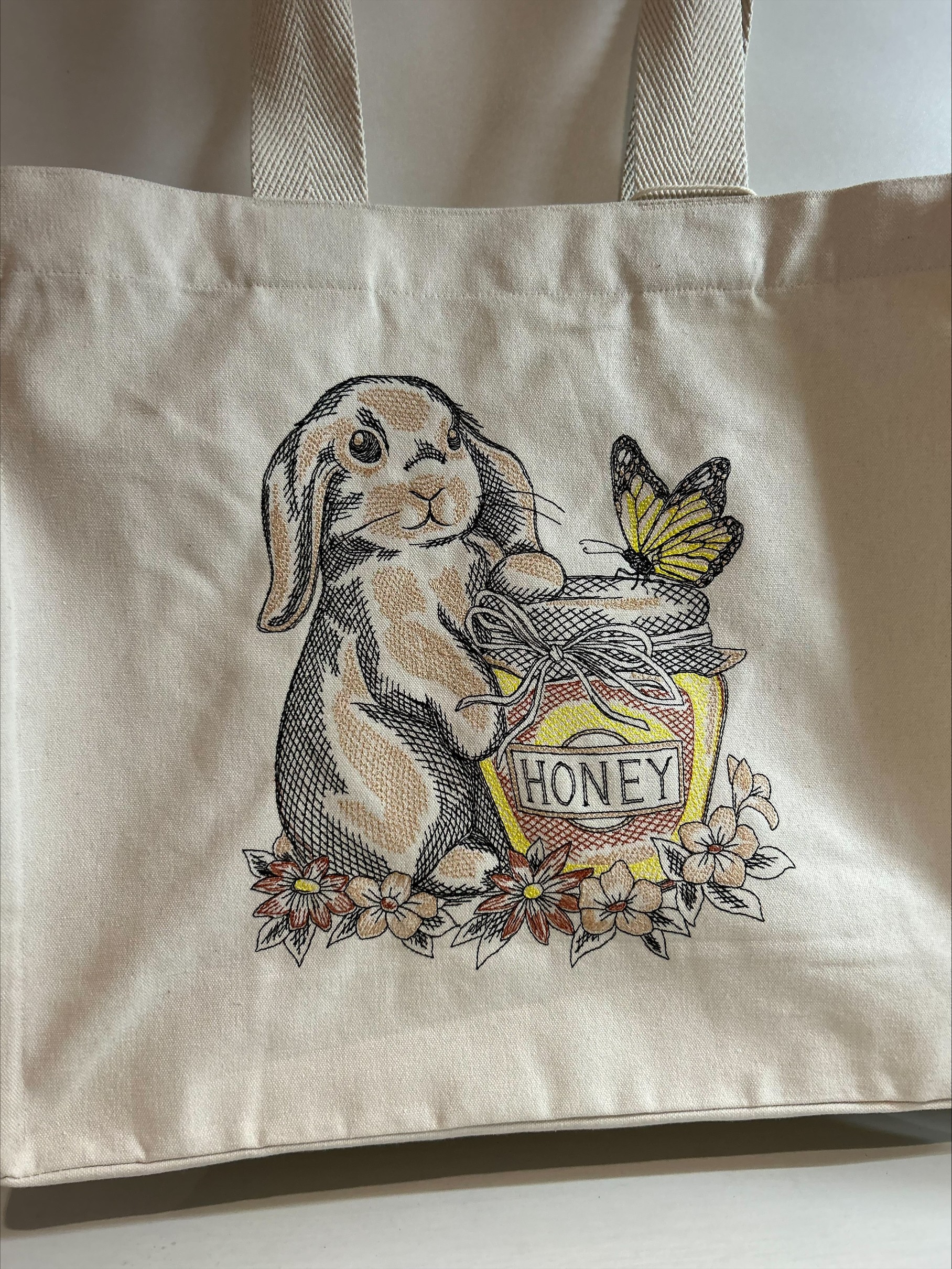 totebag sac en coton brodé avec un lapin et un pot de miel et un papillon