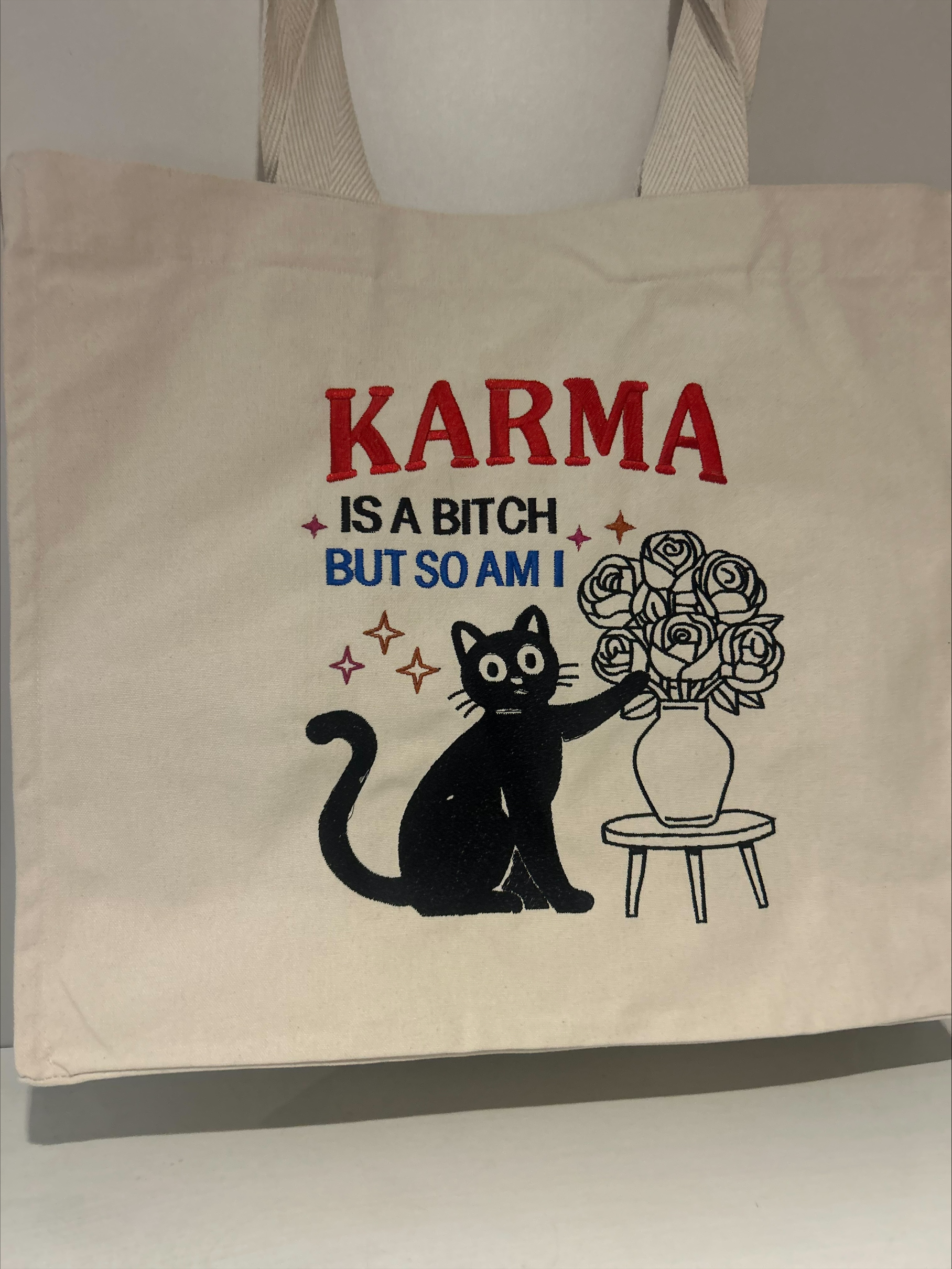 totebag sac cabas en coton avec un chat qui renverse des fleurs et parle du karma