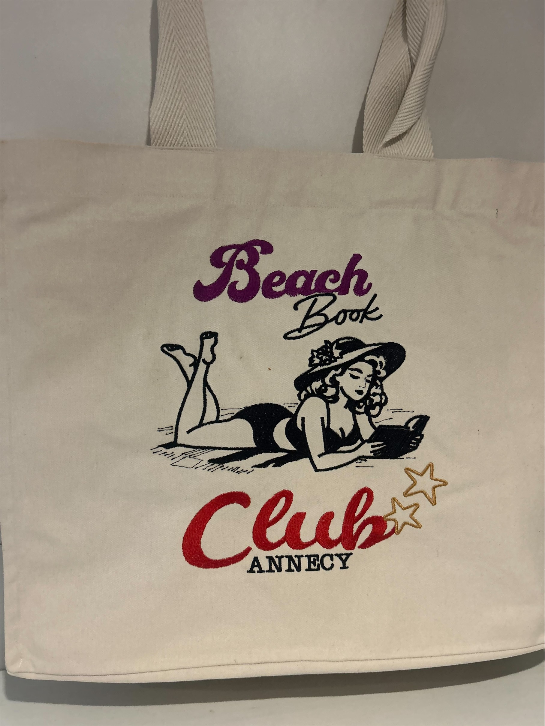 totebag sac cabas en coton d'une fille allongée à la plage d'annecy avec un livre